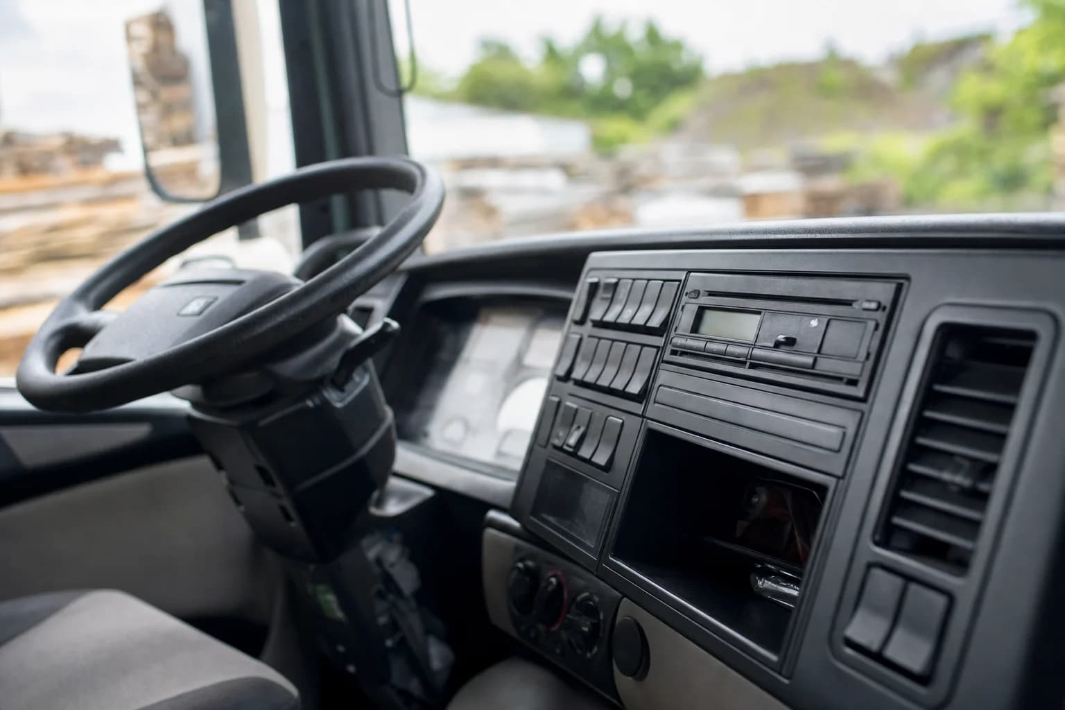 Blick in eine leere LKW-Fahrerkabine mit Lenkrad und Armaturenbrett.